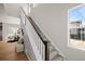Elegant staircase with carpeted steps and white railing leading to the upper level, with view to the kitchen at 5928 N Lisbon St, Aurora, CO 80019