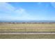 Scenic view of vacant land with mountains in the distance beneath a partly cloudy sky at 5928 N Lisbon St, Aurora, CO 80019