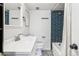 Modern bathroom featuring a vanity, toilet, and shower with a blue tile surround and a stylish black and white patterned floor at 888 N Logan St # 5A, Denver, CO 80203