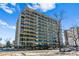 Exterior view of a high-rise apartment building with multiple balconies and street parking at 888 N Logan St # 5A, Denver, CO 80203