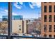 Balcony view overlooking the city skyline, with distant mountains and nearby buildings visible at 888 N Logan St # 5A, Denver, CO 80203