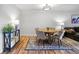 Cozy dining room area with round wood table, four chairs, hardwood floors and an adjacent living area at 888 N Logan St # 5A, Denver, CO 80203