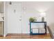 Bright entryway with light wood floors, white door, and blue console table with decorative items at 888 N Logan St # 5A, Denver, CO 80203