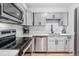 Bright kitchen featuring gray cabinets, subway tile backsplash, stainless steel appliances, and hardwood floors at 888 N Logan St # 5A, Denver, CO 80203