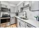Modern kitchen featuring gray cabinets, subway tile backsplash, stainless steel appliances, and hardwood floors at 888 N Logan St # 5A, Denver, CO 80203