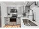 Modern kitchen featuring stainless steel appliances, white subway tile backsplash, gray cabinets, and quartz countertops at 888 N Logan St # 5A, Denver, CO 80203