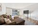 Comfortable living room with hardwood flooring, a plush sectional sofa, and a sliding glass door to a balcony at 888 N Logan St # 5A, Denver, CO 80203