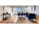 Inviting living room featuring hardwood floors, two blue sofas, modern artwork and sliding glass doors to a balcony at 888 N Logan St # 5A, Denver, CO 80203