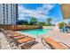 Outdoor pool area with lounge chairs, surrounded by trees and a building, perfect for relaxation and recreation at 888 N Logan St # 5A, Denver, CO 80203