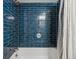 Stylish shower featuring blue subway tile, modern fixtures, and a shower curtain for a contemporary and functional space at 888 N Logan St # 5A, Denver, CO 80203