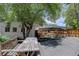 Large backyard with a wooden fence, mature tree, and a charming dining area at 1315 Gaylord St, Denver, CO 80206