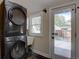 Convenient laundry area featuring a stacked washer and dryer near an access door at 1315 Gaylord St, Denver, CO 80206