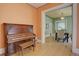 Bright living room featuring hardwood floors, a vintage piano, and a view into the dining room at 1315 Gaylord St, Denver, CO 80206