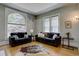 Relax in this living room with large windows, hardwood floors and two black sofas at 1315 Gaylord St, Denver, CO 80206