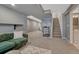 Spacious finished basement area featuring a green sofa, a treadmill and stairs to upper level at 12521 S Elk Creek Way, Parker, CO 80134