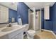 Bathroom featuring dark blue walls, a tiled shower stall and a white vanity at 12521 S Elk Creek Way, Parker, CO 80134