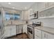 Bright kitchen with stainless steel appliances and white cabinetry at 12521 S Elk Creek Way, Parker, CO 80134