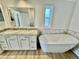 Bathroom with double sink vanity, large mirror and soaking tub at 8362 Jasmine St, Commerce City, CO 80022