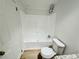 Bathroom with tub and shower combo, white tile surround and white fixtures at 8362 Jasmine St, Commerce City, CO 80022