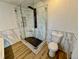 Bathroom featuring a glass shower, corner seat, marble tile walls, and hardwood flooring at 8362 Jasmine St, Commerce City, CO 80022