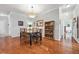 A dining room featuring hardwood floors, a modern light fixture, and a glass-top dining table at 10007 Martin Luther King Blvd # 104, Denver, CO 80238
