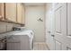 A functional laundry room with a washer, dryer, shelving, and built-in cabinets at 10007 Martin Luther King Blvd # 104, Denver, CO 80238