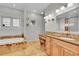 Bright bathroom featuring stone floors, wooden cabinets, a tub and many windows for natural light at 1012 S Addison Way, Aurora, CO 80018