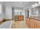 Bright bathroom featuring tiled floors, wooden cabinets, a tub and a vanity area at 1012 S Addison Way, Aurora, CO 80018