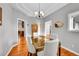Formal dining room features modern chandelier, wood floors, and an elegant glass dining table at 1012 S Addison Way, Aurora, CO 80018
