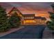 A picturesque home with a welcoming porch and three-car garage is surrounded by lush trees at sunset at 1012 S Addison Way, Aurora, CO 80018