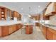 Open-concept kitchen features granite countertops, stainless appliances, large island with seating, and wood cabinetry at 1012 S Addison Way, Aurora, CO 80018