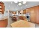 Eat-in kitchen featuring stainless appliances, granite countertops, wood cabinets, and a large island with seating at 1012 S Addison Way, Aurora, CO 80018
