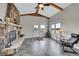 Inviting living room with a stone fireplace, beamed ceiling, large windows, and tile flooring at 1012 S Addison Way, Aurora, CO 80018