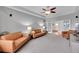 Inviting living room with comfortable leather sofas, a ceiling fan, and bright natural light, ideal for gatherings at 1012 S Addison Way, Aurora, CO 80018