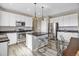 Modern kitchen features white cabinets, stainless steel appliances, a center island with stool seating, and pendant lighting at 1171 Nathan Pl, Erie, CO 80026