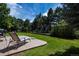 Spacious backyard with a lounge chair, grassy area, and mature trees, ideal for relaxation and recreation at 6271 S Billings Way, Centennial, CO 80111