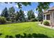 Well-manicured backyard with a black fence, mature trees, and a lush lawn, offering privacy and serenity at 6271 S Billings Way, Centennial, CO 80111