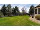 Picturesque backyard with a lush green lawn, mature trees, and a black fence, offering privacy and tranquility at 6271 S Billings Way, Centennial, CO 80111