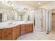 Bright bathroom features a double sink vanity, walk-in glass shower, and neutral tile floor at 6271 S Billings Way, Centennial, CO 80111