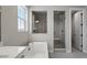 Modern bathroom features a separate tub and glass-enclosed shower with neutral-toned tile and marble countertops at 3327 Backdrop Ct, Castle Rock, CO 80108