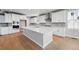 Modern kitchen features white cabinets, stainless steel appliances, and a large center island with quartz countertops at 3327 Backdrop Ct, Castle Rock, CO 80108