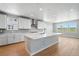 Modern kitchen with white cabinets, granite counters, stainless steel appliances, large island, and hardwood floors at 3327 Backdrop Ct, Castle Rock, CO 80108