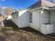 Side view of a white home with blue trimmed windows and a partially fenced yard at 410 Baker St, Longmont, CO 80501
