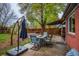 Spacious backyard featuring a patio area, outdoor dining set, and mature trees for shade at 3200 W Chenango Ave, Englewood, CO 80110