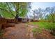 Backyard featuring mature trees, shed, wooden fence, patio, and grass at 3200 W Chenango Ave, Englewood, CO 80110