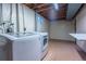 Unfinished basement features laundry area with modern washer and dryer set, plus open space for storage or customization at 3200 W Chenango Ave, Englewood, CO 80110