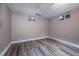 Small bedroom featuring wood-look flooring, two windows, and light-colored walls at 3200 W Chenango Ave, Englewood, CO 80110