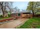 Charming brick home featuring a beautifully landscaped front yard, complemented by mature trees at 3200 W Chenango Ave, Englewood, CO 80110