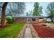 Charming red brick home with well-manicured lawn, blue shutters, and a welcoming walkway at 3200 W Chenango Ave, Englewood, CO 80110