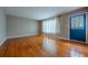 Bright living room with hardwood floors, large window, and classic blue front door at 3200 W Chenango Ave, Englewood, CO 80110